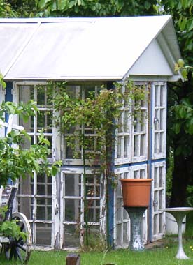 Kleines Gewächshaus aus alten Sprossenfenstern in Blau-Weißer-Gestaltung