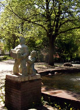 Brunnen mit Akkordeonspieler im sommerlichen Lindenpark